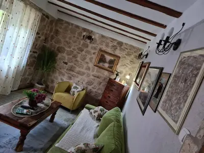 a living room with a couch and a table at Charming 3 Bedroom House in Skaljari Montenegro with Garden View in Škaljari