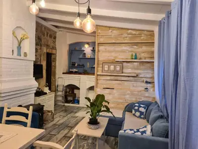 a living room with a couch and a fireplace at Charming 3 Bedroom House in Skaljari Montenegro with Garden View in Škaljari