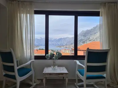 a room with two chairs and a table and a window at Charming 3 Bedroom House in Skaljari Montenegro with Garden View in Škaljari