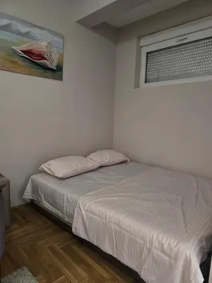 a small bedroom with a bed and a window at Apartment tuski put in Podgorica
