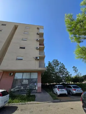 a building with cars parked in a parking lot at Apartment tuski put in Podgorica