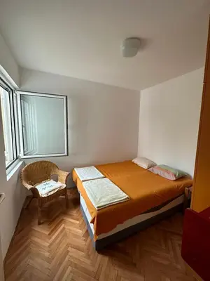 a bedroom with a bed and a chair in it at Peaceful family apartment in Budva in Budva