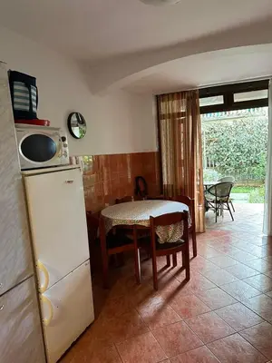 a kitchen with a refrigerator and a table with chairs at Peaceful family apartment in Budva in Budva