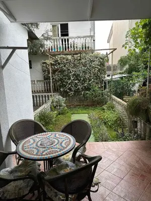 a patio with a table and chairs on a balcony at Peaceful family apartment in Budva in Budva