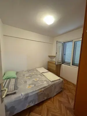 a small bedroom with a bed and a wooden floor at Peaceful family apartment in Budva in Budva