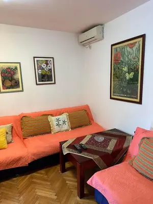 a living room with an orange couch and a table at Peaceful family apartment in Budva in Budva