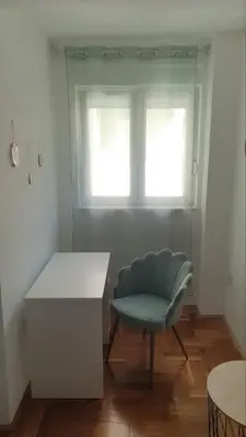 a room with a chair and a table and a window at Bojana PLUS - Sea View in Petrovac na Moru