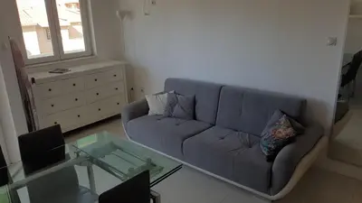 a living room with a blue couch and a glass table at Bojana PLUS - Sea View in Petrovac na Moru