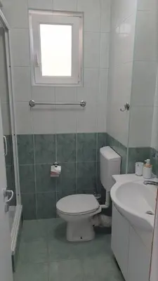 a bathroom with a toilet and a sink and a window at Bojana PLUS - Sea View in Petrovac na Moru