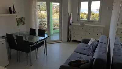 a living room with a blue couch and a glass table at Bojana PLUS - Sea View in Petrovac na Moru