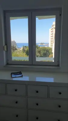 a dresser with two windows in a room with a dresser at Bojana PLUS - Sea View in Petrovac na Moru