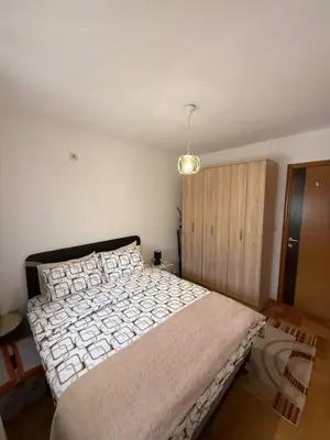 a bedroom with a large bed and a wooden cabinet at Top Apartments Vuković in Podgorica