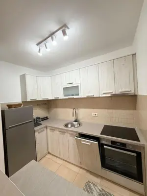 a kitchen with white cabinets and a stainless steel refrigerator at Top Apartments Vuković in Podgorica