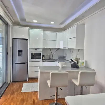 a kitchen with white cabinets and stainless steel appliances at Apartment Suka in Ulcinj