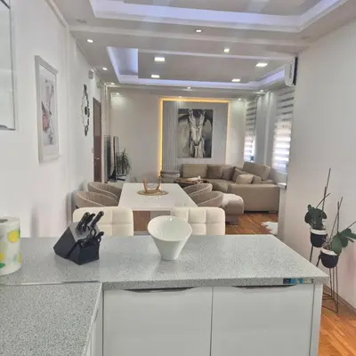 a kitchen and living room with a couch and a table at Apartment Suka in Ulcinj