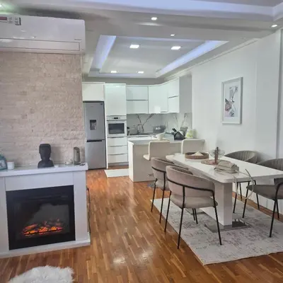 a kitchen and a living room with a fireplace at Apartment Suka in Ulcinj