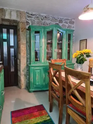 a green cabinet in a room with a table and chairs at Cheerful three bedroms house with free parking in Kotor