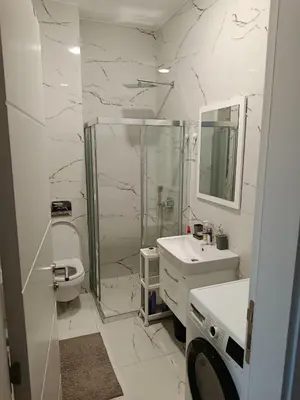 a white bathroom with a shower and a sink at Harmony in Bar