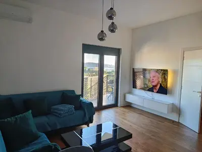 a living room with a couch and a flat screen tv at Harmony in Bar