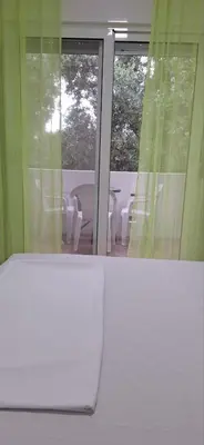 a room with a window with a table and chairs at Montebello Inn apartments in Ulcinj
