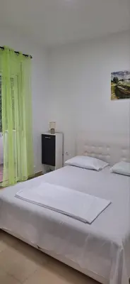 a bedroom with a large white bed and a window at Montebello Inn apartments in Ulcinj
