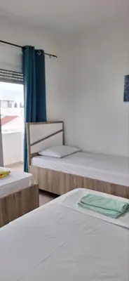 a room with three beds and a window at Montebello Inn apartments in Ulcinj