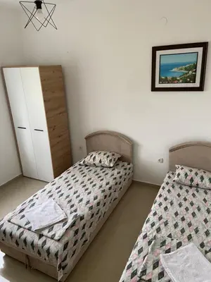 a bedroom with two beds and a dresser at Montebello Inn apartments in Ulcinj