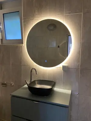 a bathroom with a sink and a round mirror at Montebello Inn apartments in Ulcinj