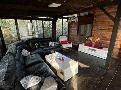 a living room with a black leather couch and a table at Sojenica Asije in Ulcinj