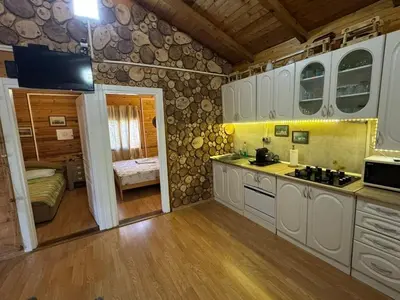 a kitchen with white cabinets and a room with a bed at Sojenica Asije in Ulcinj