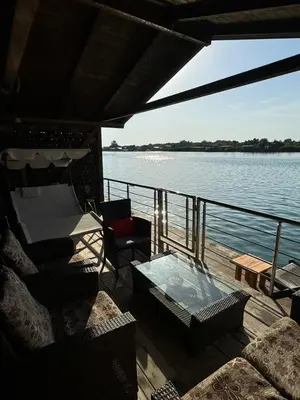 a deck of a boat with a glass table and chairs at Sojenica Asije in Ulcinj
