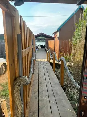 a wooden pathway with a fence and a building at Sojenica Asije in Ulcinj
