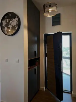a hallway with a door and a clock on the wall at Apartman Bulevar in Ulcinj