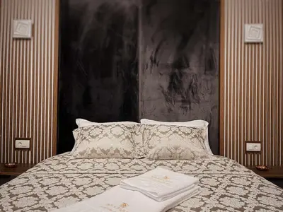 a bedroom with a bed with a large headboard at Apartman Bulevar in Ulcinj