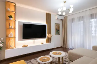 a living room with a flat screen tv on a wall at A&T Lux in Podgorica