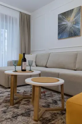 a living room with a couch and two tables at A&T Lux in Podgorica