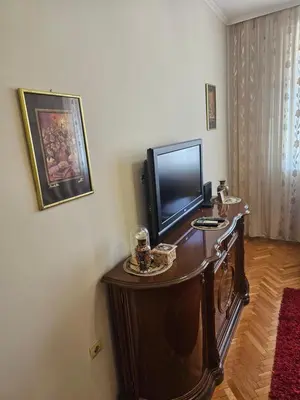a living room with a tv and a wooden table at Apartment K8 Center in Podgorica