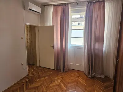 an empty room with a window and wooden floors at Apartment K8 Center in Podgorica