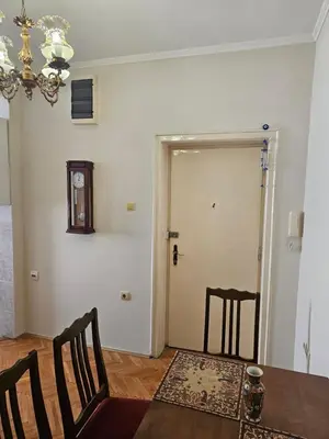 a dining room with a table and chairs and a door at Apartment K8 Center in Podgorica