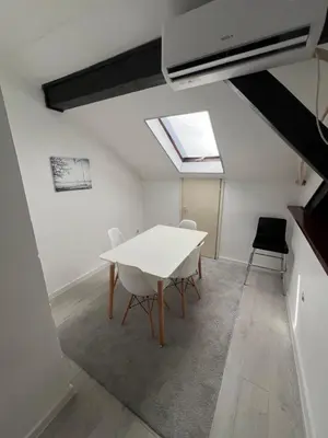 a dining room with a white table and chairs at Downtown Nest Podgorica in Podgorica