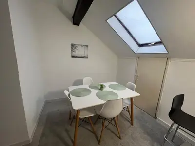 a dining room with a white table and a skylight at Downtown Nest Podgorica in Podgorica