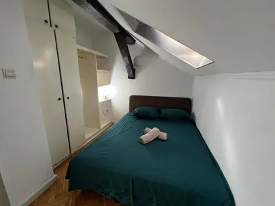 a bedroom with a green bed with a stuffed animal on it at Downtown Nest Podgorica in Podgorica