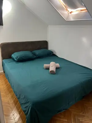 a bed with two pillows and a towel on it at Downtown Nest Podgorica in Podgorica