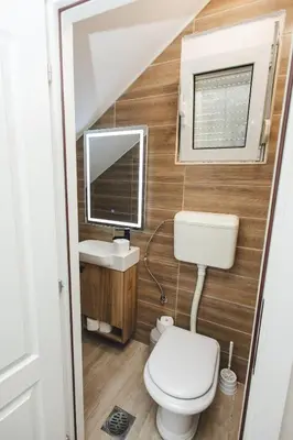 a bathroom with a toilet and a computer on the wall at Stara Varos in Podgorica