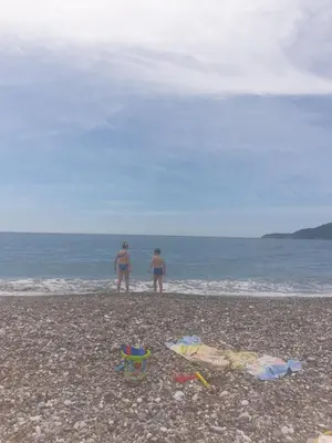 two people standing on a beach near the ocean at Ana in Becici