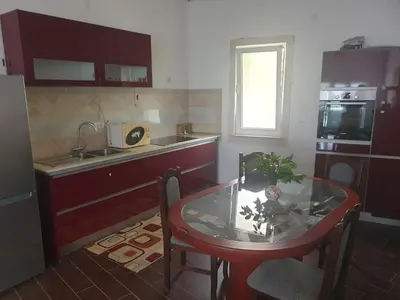 a kitchen with a table and a sink and a table and chairs at Ana in Becici