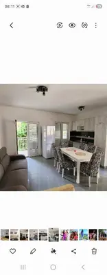 a kitchen and a living room with a table and chairs at Ana in Becici