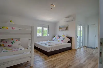 a bedroom with a bunk bed and two bunk beds at Biševo Apartmani in Donji Štoj