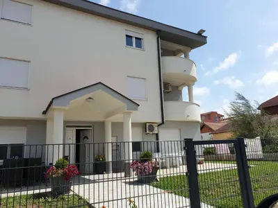 a white house with a fence in front of it at Biševo Apartmani in Donji Štoj