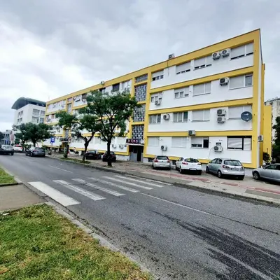 an empty street with cars parked in front of a building at Manjastan in Podgorica